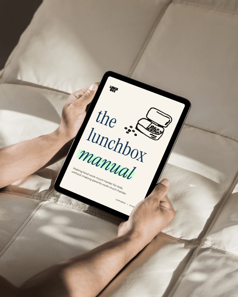 The Lunchbox Manual open on a tablet, held in two hands