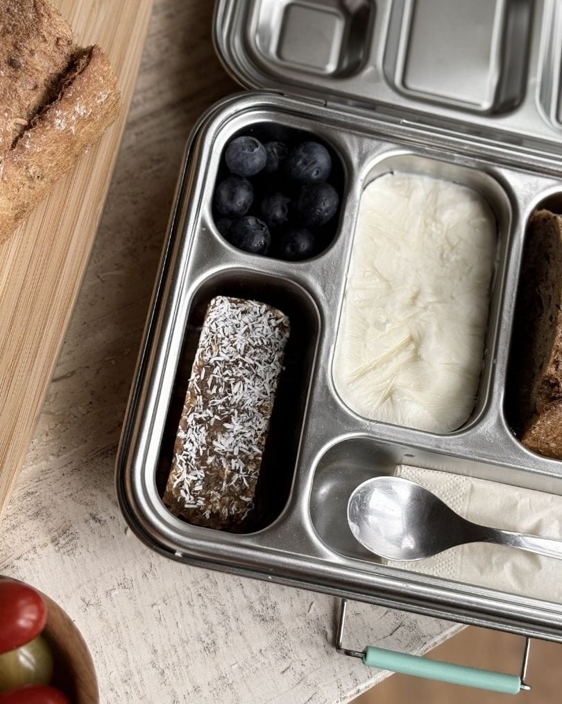 A real packed lunchbox — blueberries, bread and a bliss ball